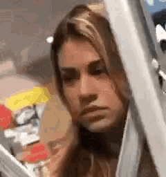 a woman is looking out of a window while wearing a face mask .
