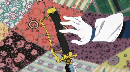 a hand in a white glove holds a sword in front of a colorful quilt