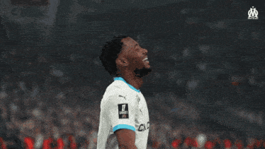 a soccer player wearing a white shirt with cmacgi on it