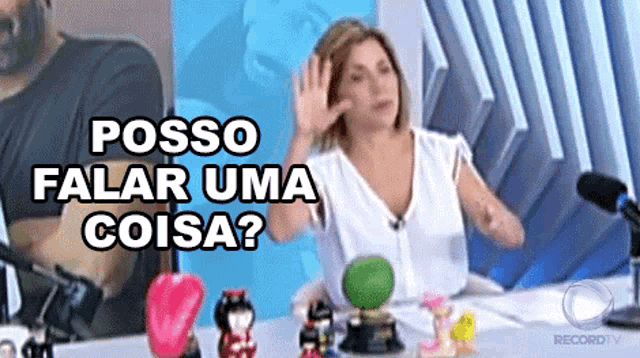 a woman sitting in front of a microphone with the words posso falar uma coisa below her
