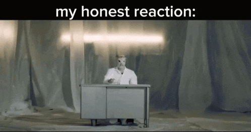 a man in a white lab coat sits at a desk with the words " my honest reaction " on the bottom