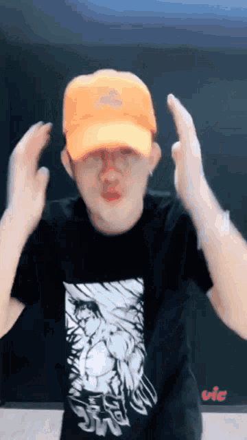 a man wearing an orange hat and a t-shirt that says vic