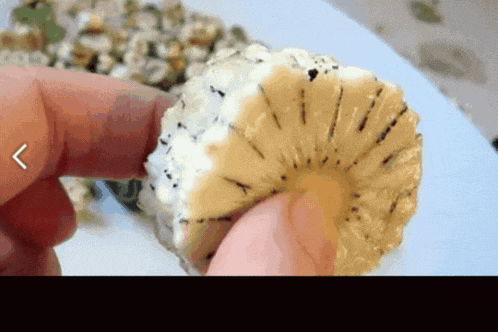 a person is holding a slice of pineapple with a arrow pointing to the left