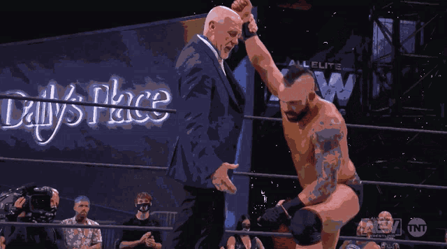 two men in a wrestling ring with a sign that says daily place