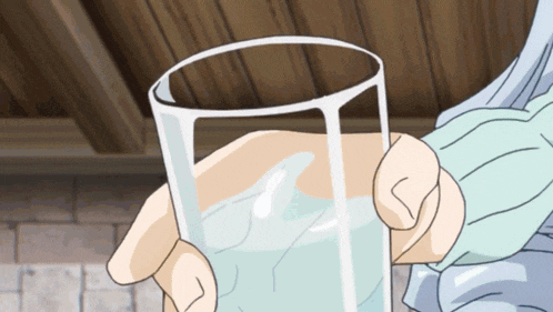 a person is holding a glass of water with ice in it