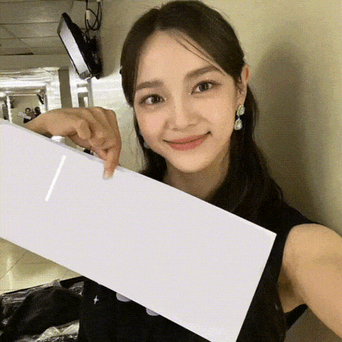 a woman is holding a piece of white paper in her hand