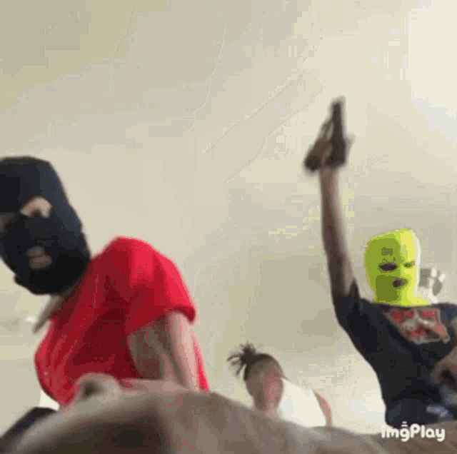 a group of people wearing ski masks are standing in a room holding guns .