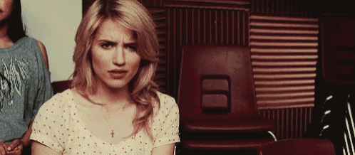 a woman is sitting in a row of chairs and looking at the camera