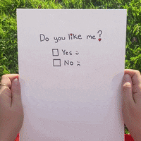 a person is holding up a piece of paper that says do you like me