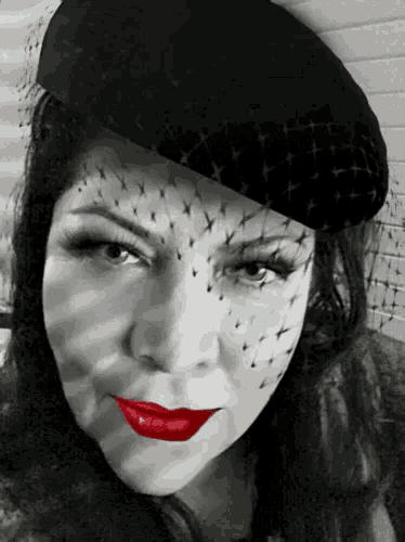 a woman with red lips wearing a black hat