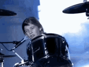 a person playing a drum set with a microphone