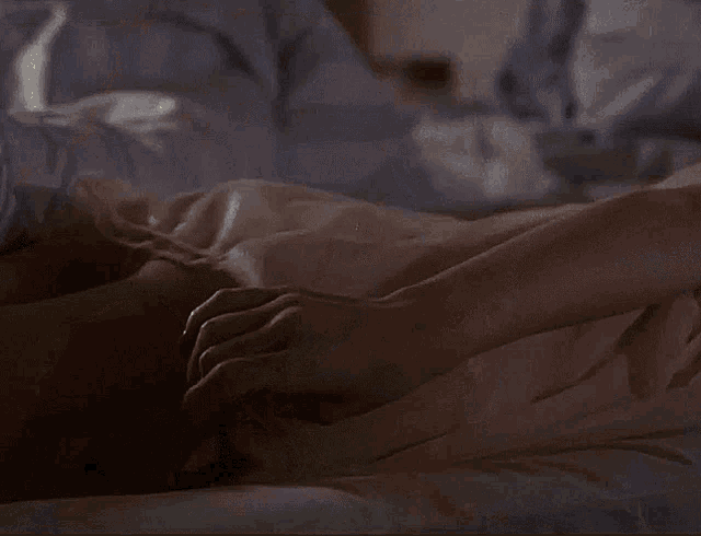 a woman laying on a bed holding a thermometer in her hand