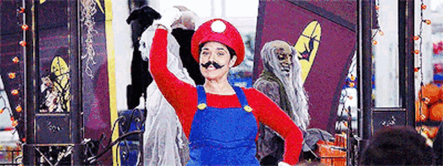 a woman in a mario costume is standing in front of a store .