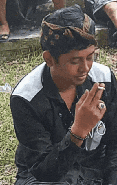 a man with a ring on his finger is smoking
