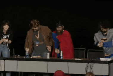 a group of people standing around a table with one wearing a shirt that says ' al ' on it