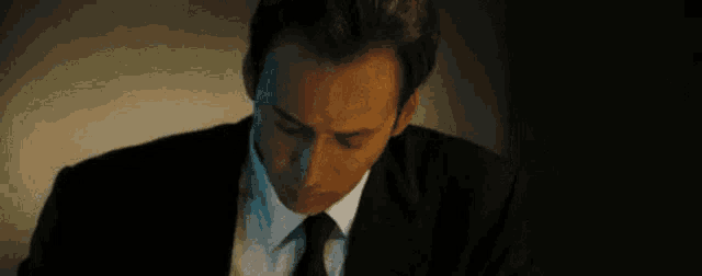 a man in a suit and tie is making a surprised face .