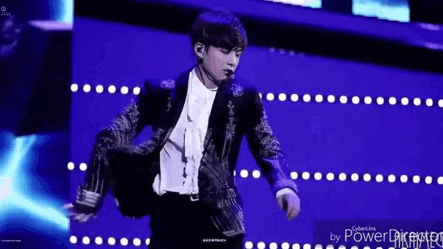 a man is standing on a stage holding a microphone .