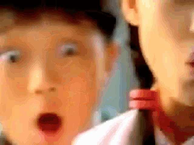 a close up of a person 's face with a surprised look on his face .