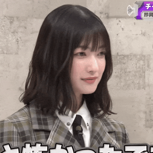 a girl wearing a plaid jacket and tie with chinese writing