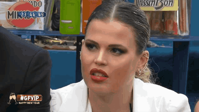 a woman wearing a white jacket and red lipstick is on a screen that says #gfvip