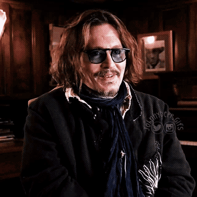 a man wearing sunglasses and a scarf has the name johnny dope written on his jacket