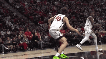 a basketball player with the number 10 on his jersey jumps in the air