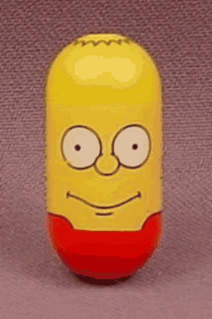 a yellow and red capsule with bart simpson 's face drawn on it .