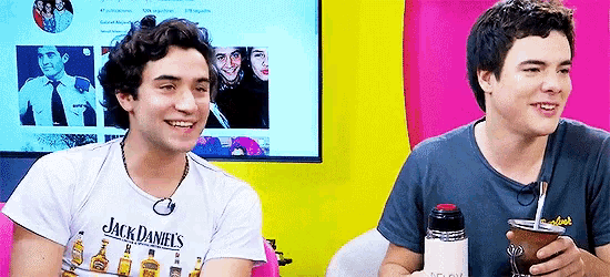 a man wearing a jack daniels t-shirt is sitting next to another man