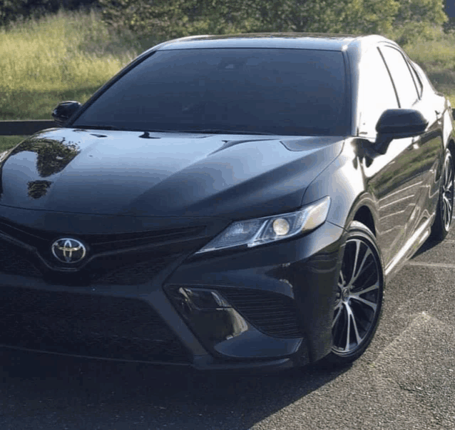 a black toyota car is parked on a road