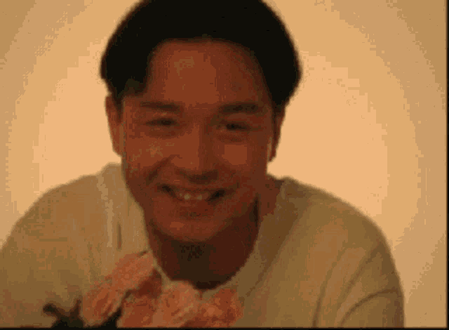 a man is smiling and holding a bouquet of pink flowers .
