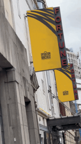 a sign for the fortune theater hangs from a building