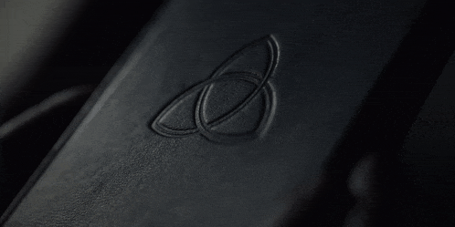 a close up of a black leather wallet with a celtic symbol on it .