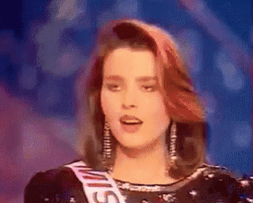 a woman with red hair is wearing a miss universe sash .