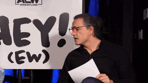 a man in front of a sign that says hey