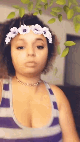 a woman with a flower crown on her head is wearing a purple tank top