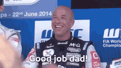 a man in a racing suit is smiling and saying good job dad