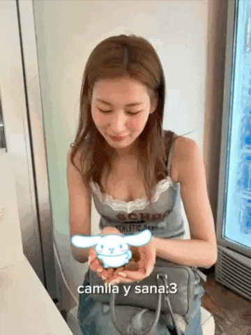 a woman is holding a stuffed animal in her hands and says camila y sana 3