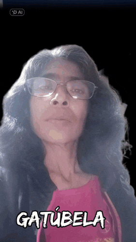 a woman wearing glasses and a pink shirt says gatubela in white letters