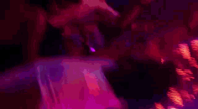 a person is dancing in front of a purple light