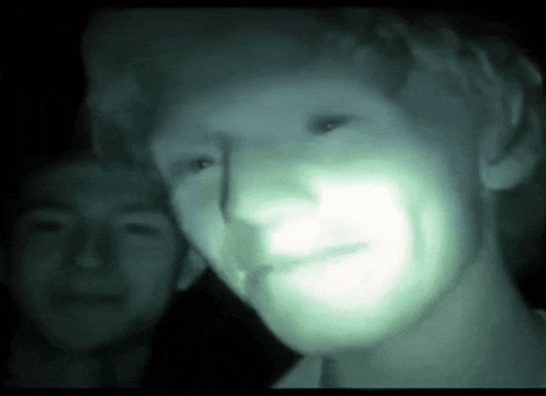 a blurry picture of a man 's face with a green light shining on it