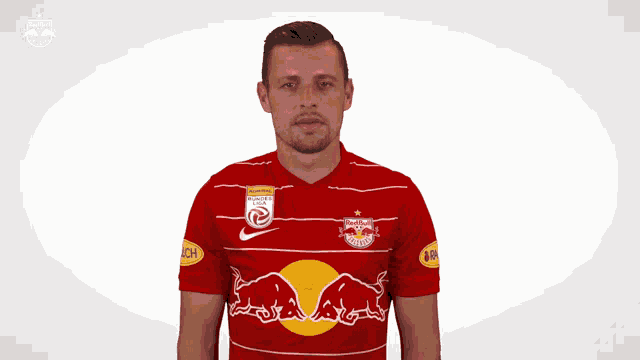 a man wearing a red and white jersey with a red bull on the front