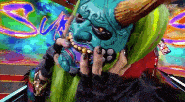 a person wearing a blue mask with horns and a green hood .