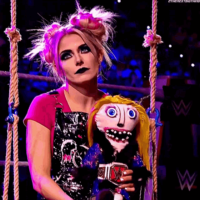 a woman is holding a puppet with a face on it