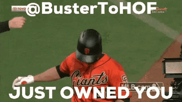 a baseball player wearing a giants jersey wipes his face with his hand