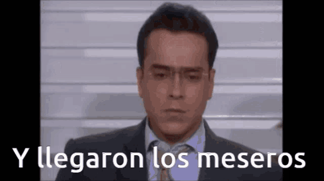 a man in a suit and tie with the words y llegaron los meseros written below him