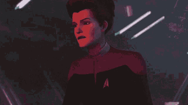 a woman in a star trek uniform is standing in front of a purple wall