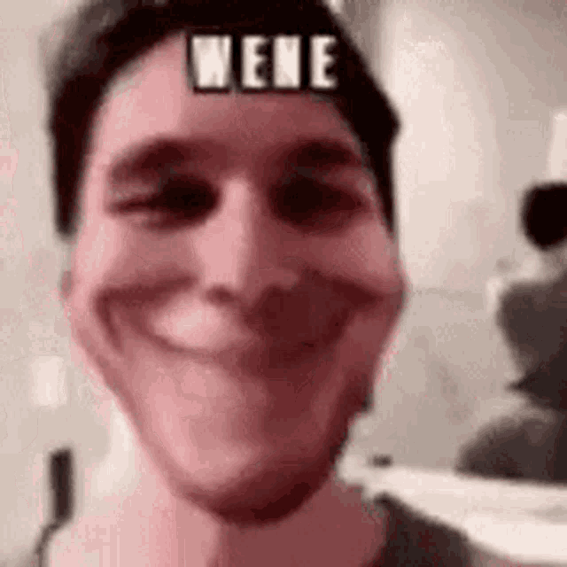 a close up of a man 's face with a funny face and the word nene on his forehead .