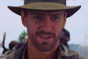 a man with a beard wears a hat and smiles