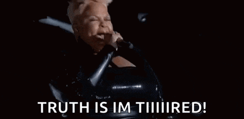 a woman in a black dress is singing into a microphone and saying `` truth is im tiiiiired ! ''