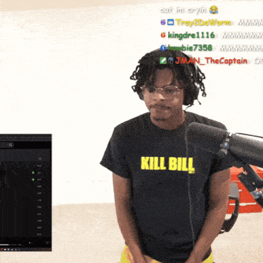 a man wearing a kill bill t-shirt is standing in front of a microphone